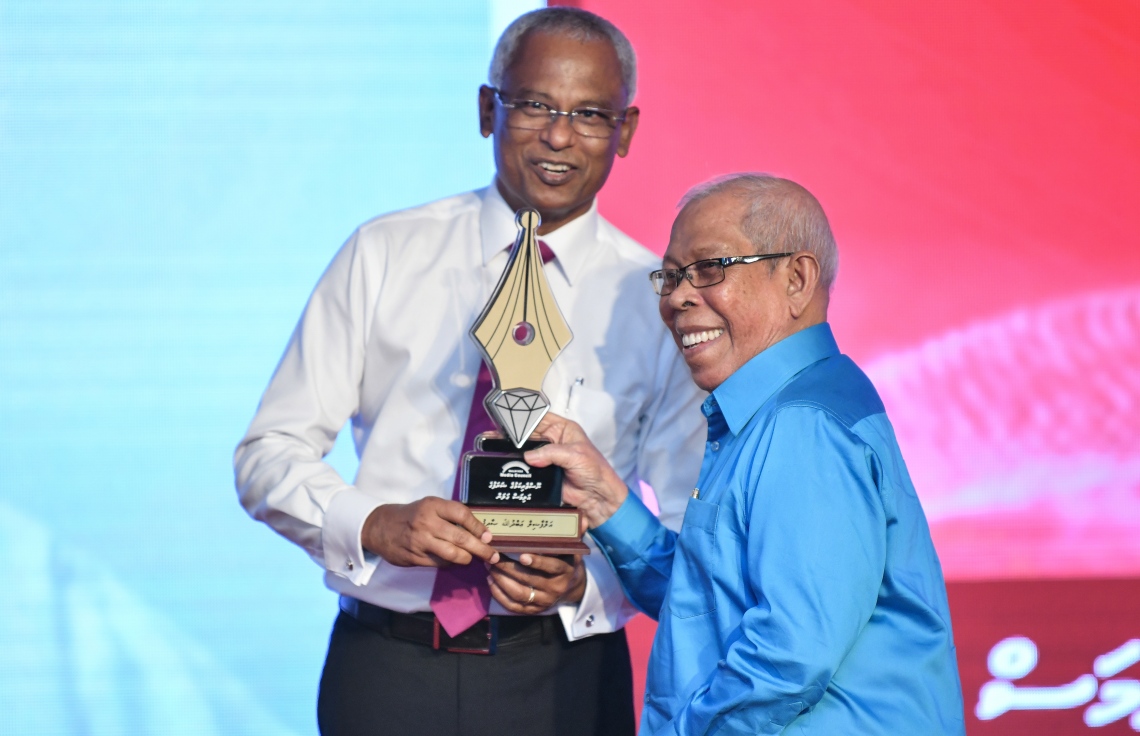 މާލެ: ޑިސެމްބަރު 11، 2018: ރާއްޖޭގެ ނޫސްވެރިކަމަށް 75 އަހަރު ފުރުމުގެ އަލިމަސްޔޫބީލް ފާހަގަ ކުރުމަށާއި ނޫސްވެރިކަމުގެ މިދިޔަ އަހަރުގެ އިނާމުތައް ދިނުމަށް މޯލްޑިވްސް މީޑިއާ ކައުންސިލާއި ހޯމް މިނިސްޓްރީ ގުޅިގެން ބޭއްވި ޖަލްސާގައި ނޫސްވެރިކަމުގެ ޝަރަފުގެ އަލިމަސް ގަލަން ހާސިލްކުރެއްވި އަބްދުﷲ ސޯދިގު (ސޯދުބެ)އަށް ރައީސް އިބްރާހިމް މުހައްމަދު ސޯލިހް އެވޯޑު ދެއްވަނީ.---ފޮޓޯ: އަހުމަދު ނިޝާތު/މިހާރު