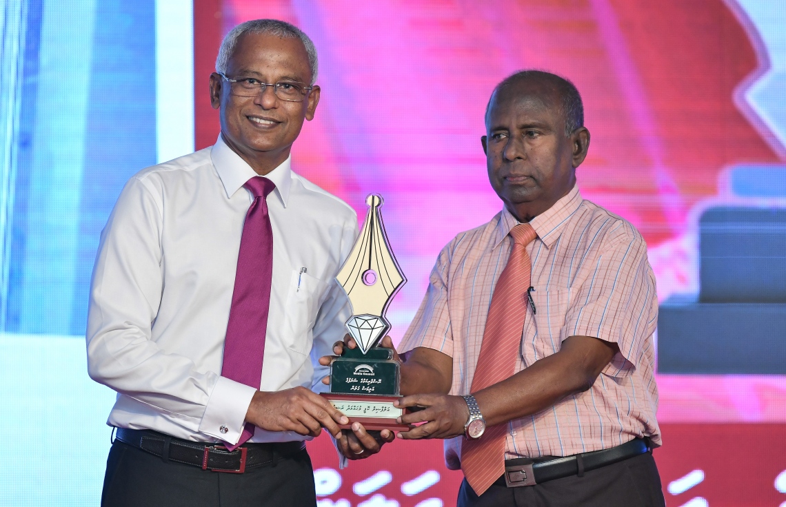 މާލެ: ޑިސެމްބަރު 11، 2018: ރާއްޖޭގެ ނޫސްވެރިކަމަށް 75 އަހަރު ފުރުމުގެ އަލިމަސްޔޫބީލް ފާހަގަ ކުރުމަށާއި ނޫސްވެރިކަމުގެ މިދިޔަ އަހަރުގެ އިނާމުތައް ދިނުމަށް މޯލްޑިވްސް މީޑިއާ ކައުންސިލާއި ހޯމް މިނިސްޓްރީ ގުޅިގެން ބޭއްވި ޖަލްސާގައި ނޫސްވެރިކަމުގެ އަލިމަސް ޝަރަފުގެ ގަލަން ހާސިލްކުރެއްވި ބޭފުޅުންގެ ތެރެއިން ކޮޕީ މުހައްމަދު ރަޝީދުއަށް ރައީސް އިބްރާހިމް މުހައްމަދު ސޯލިހް އެވޯޑު ދެއްވަނީ.---ފޮޓޯ: އަހުމަދު ނިޝާތު/މިހާރު