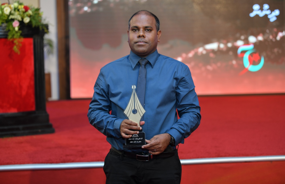 މާލެ: ޑިސެމްބަރު 11، 2018: ރާއްޖޭގެ ނޫސްވެރިކަމަށް 75 އަހަރު ފުރުމުގެ އަލިމަސްޔޫބީލް ފާހަގަ ކުރުމަށާއި ނޫސްވެރިކަމުގެ މިދިޔަ އަހަރުގެ އިނާމުތައް ދިނުމަށް މޯލްޑިވްސް މީޑިއާ ކައުންސިލާއި ހޯމް މިނިސްޓްރީ ގުޅިގެން ބޭއްވި ޖަލްސާގައި ނޫސްވެރިކަމުގެ ރަން ގަލަން ހާސިލްކުރެއްވި ބޭފުޅުންގެ ތެރެއިން މިހާރު"ގެ އެޑިޓަރު އަހުމަދު ހަމްދޫން ފޮޓޯއަކަށް ހުއްޓިގެން.---ފޮޓޯ: އަހުމަދު ނިޝާތު/މިހާރު