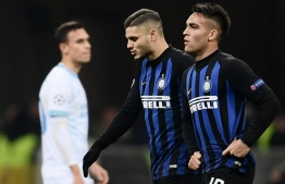 Inter Milan's Argentine forward Mauro Icardi (C) and Inter Milan's Argentine forward Lautaro Martinez leave the pitch at the end of the UEFA Champions League group B football match Inter Milan vs PSV Eindhoven on December 11, 2018 at the San Siro stadium in Milan. (Photo by Marco BERTORELLO / AFP)