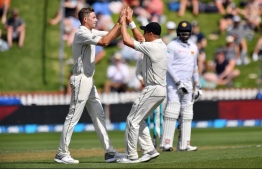 New Zealand's paceman Tim Southee (L) celebrates the dismissal of Sri Lanka's batsman Dinesh Chandimal with teammate Neil Wagner during day one of the first Test cricket match between New Zealand and Sri Lanka at the Basin Reserve in Wellington on December 15, 2018. (Photo by Marty MELVILLE / AFP)