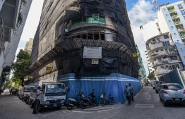 Pedestrians walk past a construction site in Male' City. PHOTO: AHMED NISHAATH / MIHAARU