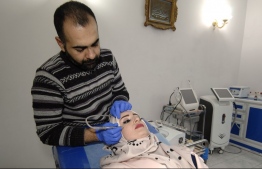 An Iraqi woman gets a facial treatment at a beauty clinic in the northern city of Mosul on November 19, 2018. - For three years, Mosul's women were covered in black from head to toe and its men had to keep their beards long. Salons were shut, and plastic surgery considered a crime. Today, Mosul's plastic surgeons and beauticians are at service. (Photo by Zaid AL-OBEIDI / AFP)