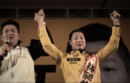 This file photo taken on January 14, 2016 shows Freddy Lim (R), a candidate from the New Power Party and singer of ChthoniC - one of Asia's biggest death metal bands - attending an election rally in Taipei. - A popular Taiwan heavy metal band which advocates independence for the island announced on December 22, 2018 it had been forced to cancel a gig in Hong Kong after city authorities dragged their feet on granting them a visa. (Photo by PHILIPPE LOPEZ / AFP)
