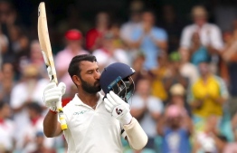 India's Cheteshwar Pujara kisses his helmet after reaching his century (100 runs) during the first day of the fourth and final cricket Test against Australia at the Sydney Cricket Ground in Sydney on January 3, 2019. (Photo by DAVID GRAY / AFP) / 
