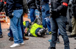 "Yellow vest" (gilets jaunes) protestors lay on the ground after being arrested by French police on the sideline of an anti-government demonstration in Lille, northern France, on January 5, 2019. - The "yellow vest" movement began in rural France over fuel taxes and quickly ballooned into a wider revolt against the 41-year-old president's pro-business policies and perceived arrogance by low-paid workers and pensioners. (Photo by Philippe HUGUEN / AFP)