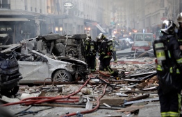 Firefighters intervene in the middle of debris after the explosion of a bakery on the corner of the streets Saint-Cecile and Rue de Trevise in central Paris on January 12, 2019. - A large explosion badly damaged a bakery in central Paris on January 12, injuring several people and smashing windows in surrounding buildings, police and AFP journalists at the scene said. A fire broke out after the blast at around 9am (0800 GMT) in the busy 9th district of the city, which police suspect may have been caused by a gas leak. (Photo by Thomas SAMSON / AFP)