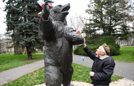 93-year-old former Polish soldier Wojciech Narebski stands in front of a monument of brown bear Wojtek who was his fellow Polish servicemen during World War II in Krakow on November 14, 2018. - The unbelievable true story of the orphaned cub, who was found by Polish troops in Persia and then travelled through Iraq, Syria, Palestine, Egypt, Italy, and Scotland as a morale-booster, is now being turned into an animated movie. (Photo by Janek SKARZYNSKI / AFP)
