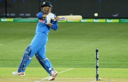 (FILES) In this file photo taken on January 15, 2019 Indian batsman Mahendra Singh Dhoni hits the ball during the second one-day international cricket match between Australia and India at the Adelaide Oval. - Mahendra Singh Dhoni on January 16 got plaudits for his match-winning fifty in India's series-levelling win over Australia as he answered his critics with a 'classic' finishing job. (Photo by Brenton EDWARDS / AFP) / 