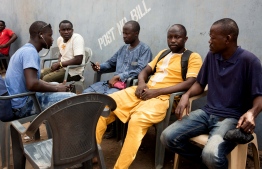 Mansuru Tahiru (2nd R) the cousin of murdered Ghanian undercover reporter Ahmed Hussein Suale sits with friends during a mourning gathering in Accra on January 17, 2019. - Family and friends gather to discuss the murder of Ghanian undercover reporter Ahmed Hussein Suale at a popular spot where he used to sit and drink with family and friends in Accra. Ghanaian police on January 17, 2019 opened an investigation after an undercover journalist who helped expose corruption in African football was shot dead. (Photo by RUTH MCDOWALL / AFP)