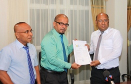 Elections Commission's President Shareef (C) presents registration document of the new Labour and Social Democratic Party.