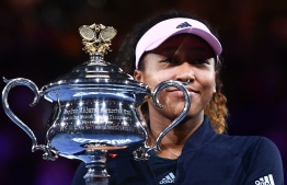 Japan's Naomi Osaka celebrates with the championship trophy during the presentation ceremony after her victory against Czech Republic's Petra Kvitova in the women's singles final on day 13 of the Australian Open tennis tournament in Melbourne on January 26, 2019. (Photo by Jewel SAMAD / AFP)