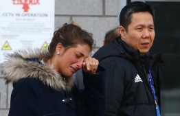 Cardiff City FC Executive Director and CEO Ken Choo (R) walks with Romina Sala (L), sister of Cardiff City's missing Argentinian footballer Emiliano Sala, whose flight disappeared from radar over the English Channel north of Guernsey, as they visit the tributes to Emiliano Sala layed outside Cardiff City Stadium in Cardiff, south Wales on January 25, 2019. - Police on January 24, 2019 ended their search for Premier League player Emiliano Sala, saying the chances of finding the Argentinian alive three days after his small plane went missing over the Channel were "extremely remote". Their decision was met with anguished disbelief by the forward's sister Romina, who, speaking through tears, begged the search teams not to give up. The light aircraft transporting the 28-year-old striker, who signed for Cardiff City at the weekend, disappeared from radar around 20 kilometres (12 miles) north of Guernsey on the night of January 21. (Photo by GEOFF CADDICK / AFP)