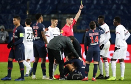 French referee Karim Abed (C) gives a yellow card to Rennes' Senegalese forward Mbaye Niang after he tackled Paris Saint-Germain's German defender Thilo Kehrer (down C) during the French L1 football match between Paris Saint-Germain (PSG) and Stade Rennais FC, at the Parc des Princes stadium, in Paris, on January 27, 2019. (Photo by Zakaria ABDELKAFI / AFP)