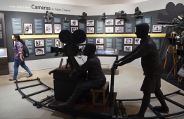 In this picture taken on January 22, 2019, an Indian student (R) visits the National Museum of Indian Cinema (NMIC), the country's first museum showcasing the history of its film industry, in Mumbai. - From silent black-and-white films to colourful blockbusters bursting with song and dance, a new museum tracing the evolution of Indian cinema has opened in the home of Bollywood. Costing 1.4 billion rupees (19.6 million USD), India's first national film museum is spread across a stylish 19th-century bungalow and a modern five-storey glass structure in south Mumbai. (Photo by PUNIT PARANJPE / AFP) / 