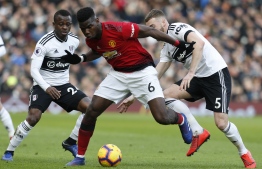Manchester United's French midfielder Paul Pogba (C) vies with Fulham's English defender Calum Chambers (R) and Fulham's Ivorian midfielder Jean Michael Seri (L) during the English Premier League football match between Fulham and Manchester United at Craven Cottage in London on February 9, 2019. - Manchester United won the game 3-0. (Photo by Ian KINGTON / AFP) / RESTRICTED TO EDITORIAL USE. No use with unauthorized audio, video, data, fixture lists, club/league logos or 'live' services. Online in-match use limited to 120 images. An additional 40 images may be used in extra time. No video emulation. Social media in-match use limited to 120 images. An additional 40 images may be used in extra time. No use in betting publications, games or single club/league/player publications. / 