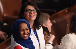US Representative Ilhan Omar (D-MN) (L) and US Representative from Michigan Rashida Tlaib  (D-MI), dressed in white in tribute to the women's suffrage movement, arrive for the State of the Union address at the US Capitol in Washington, DC, on February 5, 2019. (Photo by SAUL LOEB / AFP)