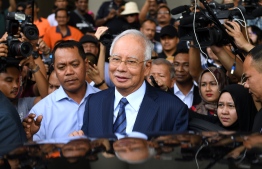 (FILES) In this file photo taken on December 12, 2018 former Malaysia's prime minister Najib Razak (C) leaves the courthouse in Kuala Lumpur after being charged. - Malaysia's disgraced ex-leader Najib Razak will go on trial over an extraordinary financial scandal that contributed to the downfall of his long-ruling coalition and has reverberated around the world. (Photo by Mohd RASFAN / AFP)