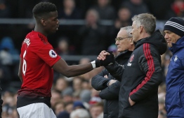 Manchester United's French midfielder Paul Pogba (L) shakes hands with Manchester United's  Norwegian caretaker manager Ole Gunnar Solskjaer after being substituted during the English Premier League football match between Fulham and Manchester United at Craven Cottage in London on February 9, 2019. (Photo by Ian KINGTON / AFP) / RESTRICTED TO EDITORIAL USE. No use with unauthorized audio, video, data, fixture lists, club/league logos or 'live' services. Online in-match use limited to 120 images. An additional 40 images may be used in extra time. No video emulation. Social media in-match use limited to 120 images. An additional 40 images may be used in extra time. No use in betting publications, games or single club/league/player publications. / 