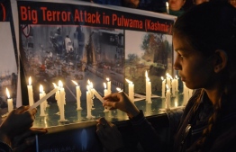 Indian school students light candles as they pay tribute to the Central Reserve Police Force (CRPF) personnel killed on February 14, during an attack on a CRPF convoy in the Lethpora area of Kashmir, in Amritsar on February 15, 2019. - India and Pakistan's troubled ties risked taking a dangerous new turn on February 15 as New Delhi accused Islamabad of harbouring militants behind the deadliest bombing in three decades of bloodshed in Indian-administered Kashmir. At least 41 paramilitary troops were killed on February 14 as explosives packed in a van ripped through a convoy bringing 2,500 troopers back from leave not far from the main city Srinagar. (Photo by NARINDER NANU / AFP)