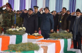In this handout photo released by Jammu and Kashmir Information Department on February 15, 2019, Indian Home Minister Rajnath Singh (3rd R), Governor of Jammu and Kashmir Satya Pal Malik and General Officer Commander-in-Chief of the Army's Northern Command Ranbir Singh salute near the coffins of the slain paramilitary Central Reserve Police Forces (CRPF) personnel during the wreath-laying ceremony at CRPF's Regional Training Centre on the outskirts of Srinagar. - India and Pakistan's troubled ties risked taking a dangerous new turn on February 15 as New Delhi accused Islamabad of harbouring militants behind the deadliest bombing in three decades of bloodshed in Indian-administered Kashmir. At least 41 paramilitary troops were killed on February 14 as explosives packed in a van ripped through a convoy bringing 2,500 troopers back from leave not far from the main city Srinagar. (Photo by Handout / Government of Jammu and Kashmir Information Department / AFP) / 