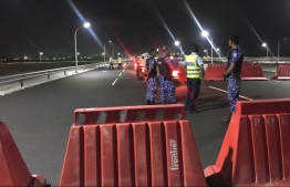 Police officers conducting a security check on a motorcycle travelling along the Sinamale' Bridge. PHOTO: MALDIVES POLICE SERVICE