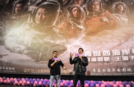 This photo taken on February 17, 2019 shows film director Guo Fan (L) and American actor Michael Stephen Kai Sui attending a promotional event for Chinese sci-fi film "The Wandering Earth" in Qingdao in China's eastern Shandong province. - China's first large-scale sci-fi blockbuster has become the country's second highest-grossing movie ever, while claiming the Chinese film box-office champion in North America in the past five years. (Photo by STR / AFP) / 