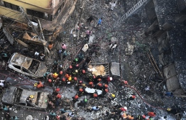 Rescue personnel carry the body of a victim after a fire broke out in Dhaka on February 21, 2019. - At least 69 people have died in a huge blaze that tore through apartment buildings also used as chemical warehouses in an old part of the Bangladeshi capital Dhaka, fire officials said on February 21. (Photo by Munir UZ ZAMAN / AFP)