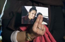 (FILES) In this file photo taken on February 22, 2015 Renu Begum, eldest sister of missing British girl Shamima Begum, holds a picture of her sister while being interviewed by the media in central London. - A British teenager who fled to join the Islamic State group in Syria is living in a refugee camp and wants to return home, The Times reported on February 14, 2019. Shamima Begum, now 19, expressed no regrets about fleeing her London life four years ago but said that two of her children had died and, pregnant with her third, she wanted to return. (Photo by LAURA LEAN / POOL / AFP)