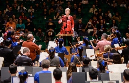 In this picture taken on February 20, 2019, US conductor Marin Alsop (top C), 62, conducts the Sao Paulo Symphony Orchestra, the Diocesan Boys' School Orchestra and the Diocesan Girls' School Orchestra as they play US composer Leonard Bernstein's 'Candide Overture' during an open rehearsal for their Hong Kong Arts Festival performance the following night in Hong Kong. - The first woman to lead a major US orchestra, Marin Alsop believes that Western classical music -- long seen as a stuffy, elitist club -- can be "a great equaliser" between people of all backgrounds. (Photo by Anthony WALLACE / AFP) / 