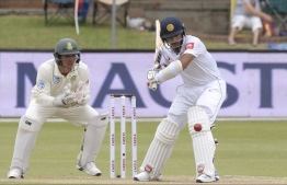 Pictured above Sri Lanka's Kusal Mendis  (R) is watched by South Africa's wicketkeeper Quinton de Kock as he plays a shot during the third day of the second Test cricket match between South Africa and Sri Lanka at St. George's Park Stadium in Port Elizabeth on February 23, 2019. International cricket came to a halt in Sri Lanka on March 13 when the visiting England team pulled out on the second day of a practice match ahead of their two-Test series as the coronavirus pandemic spread. PHOTO: RODGER BOSCH / AFP