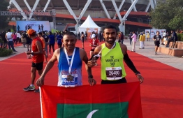 Mohamed Rasheed and Nasru posing with the Maldivian flag after the race. PHOTO: MIHAARU