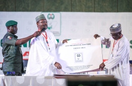 Nigeria's Independent National Electoral Commission (INEC) chairman Mahmood Yakubu displays vote result sheets on February 25, 2019 in Abuja during the presidential elections announcement. - Muhammadu Buhari got off to a winning start in his bid for re-election as Nigeria's president, as the first result was announced today from weekend polls. The 76-year-old former military ruler won 219,231 votes in the southwestern state of Ekiti, while his main opponent, Atiku Abubakar, got 154,032, the electoral commission announced. (Photo by Kola SULAIMON / AFP)