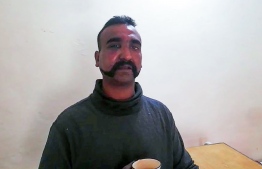 This handout photograph released by Pakistan's Inter Services Public Relations (ISPR) on February 27, 2019, shows captured Indian pilot looking on as holding a cup of tea in the custody of Pakistani forces in an undisclosed location. - Pakistan's state media on February 27 published a video showing an Indian fighter pilot who was captured after his jet was shot down when it entered Pakistani airspace in Kashmir. (Photo by HANDOUT / ISPR / AFP) / 