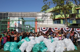Participants posing for a picture with the waste collected. PHOTO: AMERICAN CENTER
