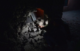 Residents use mobile lights to show what villagers says is a damaged wall by a mortar shell  fired from Pakistan, at Kalal village near Nowshera in Jammu region on February 28, 2019. - Indian forces remain on a "heightened" state of alert despite Pakistan's promise to free a pilot shot down in air raids this week, top Indian military chiefs said on February 28. (Photo by SAJJAD HUSSAIN / AFP)