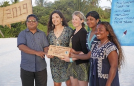 Environment Minister Dr. Hussain Rasheed Hassan presents (from left to right) Dr. Claire Petros, Dr. Cal Major, Dhafeena Hassan and Shaziya Saeed with a wooden plaque from Coco Collection and Olive Ridley Project, in recognition of their achievement. PHOTO: JAMES APPLETON PHOTOGRAPHY