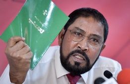 Jumhooree Party's leader Qasim Ibrahim holding up the constitution at a press conference. PHOTO: NISHAN ALI / MIHAARU