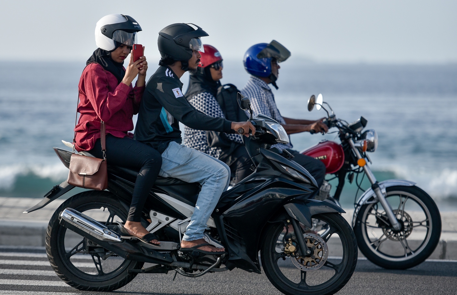 ހެލްމެޓް އަޅައިގެން ތިބި ބަޔަކު ސިނަމާލޭ ބްރިޖުގައި ދުއްވާފައި ދަނީ ފޮޓޯ: މިހާރު