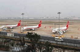 This photo taken on March 11, 2019 shows three Boeing 737 MAX 8 planes from Shanghai Airlines parked at Shanghai Hongqiao International Airport in Shanghai. - China on March 11, 2019 ordered domestic airlines to suspend commercial operation of the Boeing 737 MAX 8, citing the Ethiopian Airlines crash and another deadly accident of that same model in Indonesia. (Photo by STR / AFP)