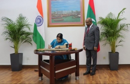 India's Minister of External Affairs Sushma Swaraj (L) signs the Guest Book at the Maldives' Ministry of Foreign Affairs. PHOTO/FOREIGN MINISTRY