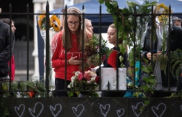 People pay their respects at a memorial site at the Botanical garden in Christchurch on March 18, 2019, three days after a shooting incident at two mosques in the city that claimed the lives of 50 Muslim worshippers. - New Zealand will tighten gun laws in the wake of its worst modern-day massacre, the government said on March 18, as it emerged that the white supremacist accused of carrying out the killings at two mosques will represent himself in court. PHOTO: MARTY MELVILLE / AFP