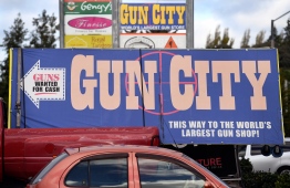 Signs point towards a gun shop in Christchurch March 21, 2019, claiming to be the world's largest gun shop. - New Zealand imposed an immediate ban on assault weapons on Thursday, taking swift action in response to the Christchurch massacre and triggering renewed calls from leading American politicians for curbs in the United States. (Photo by WILLIAM WEST / AFP)