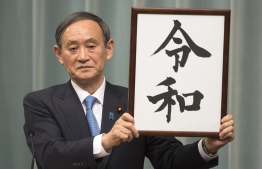 Japan's Chief Cabinet Secretary Yoshihide Suga announces the new era name "Reiwa" duringa press coference at the prime minister's office in Tokyo on April 1,2019. - Japan announced its new imperial era, which will begin next month when Emperor Akihito abdicates, will be known as "Reiwa", a word that includes the character for "harmony". (Photo by Kazuhiro NOGI / AFP)
