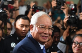 Malaysia's former prime minister Najib Razak (C) leaves a court in Kuala Lumpur on April 3, 2019, after facing his trial over alleged involvement in the looting of sovereign wealth fund 1MDB. - Malaysia's disgraced former leader Najib Razak pleaded not guilty to all charges against him as he went on trial April 3 over a multi-billion-dollar fraud. (Photo by Mohd RASFAN / AFP)