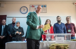 Turkish President Tayyip Erdogan (C) stands prior to cast his ballot at a polling station during the municipal elections in Istanbul, on March 31, 2019. - Turkey voted in local elections  in a test for President Recep Tayyip Erdogan, with his ruling party risking defeat in the capital as an economic slowdown takes hold. (Photo by BULENT KILIC / AFP)