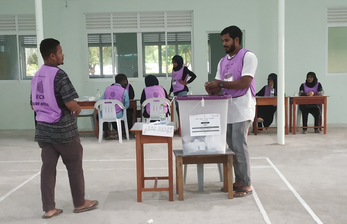 ހދ. ކުޅުދުއްފުށި: އޭޕްރިލް 6، 2019: ރައްޔިތުންގެ މަޖިލިސް އިންތިހާބުގައި ކުޅުދުއްފުށީ ދާއިރާގެ ވޯޓުލީ މަރުކަޒެއްގައި ވޯޓުލުން ބަންދުވީކަން އަންގާ ބޯޑެއް، އޮފިޝަލަކު ވޯޓު ފޮށީގައި ބައިންދަނީ.-- ފޮޓޯ: މުހައްމަދު ނަސީމް /މިހާރު