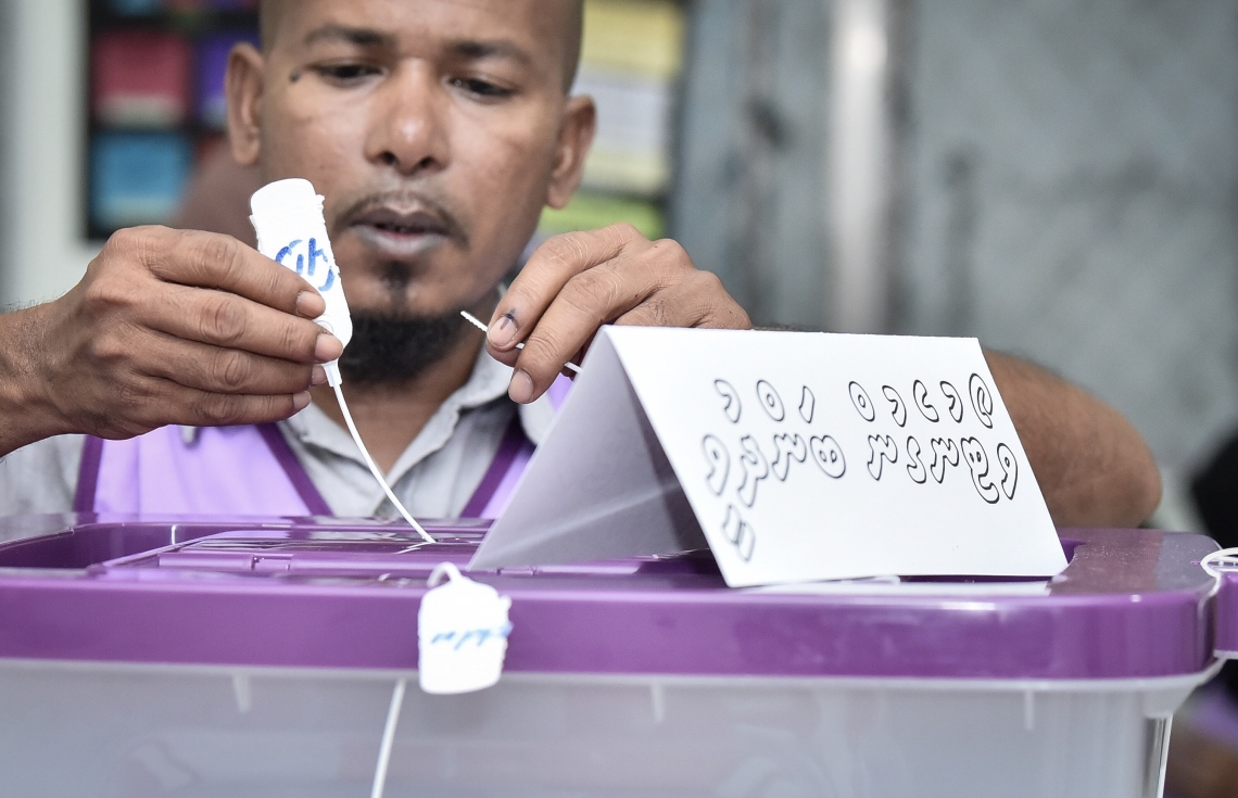 މާލެ: އޭޕްރިލް 6، 2019: ރައްޔިތުންގެ މަޖިލިސް އިންތިހާބުގައި ވޯޓުލީ މަރުކަޒެއްގައި ވޯޓުލުން ބަންދުވީކަން އަންގާ ބޯޑެއް، އޮފިޝަލަކު ވޯޓު ފޮށީގައި ބައިންދަނީ.-- ފޮޓޯ: ނިޝާން އަލީ /މިހާރު