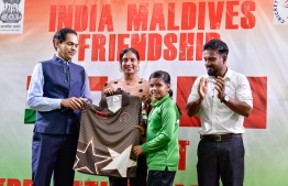 Indian Ambassador to Maldives Sunjay Sundhir and Minister of Education Dr Aishath Ali handing over sports attire to students. PHOTO: MIHAARU