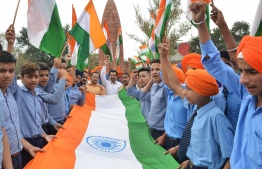 Indian school students hold Indian national flag as they pay tribute to the Jallianwala Bagh massacre martyrs' on the eve of the 100th anniversary of the Jallianwala Bagh massacre, in Amritsar on April 12, 2019. - The Amritsar massacre, also known as the Jallianwala Bagh massacre, took place on April 13, 1919, when British Indian Army soldiers on the direct orders of their British officers opened fire on an unarmed gathering killing at least 379 men, women and children, according to official records. (Photo by NARINDER NANU / AFP)